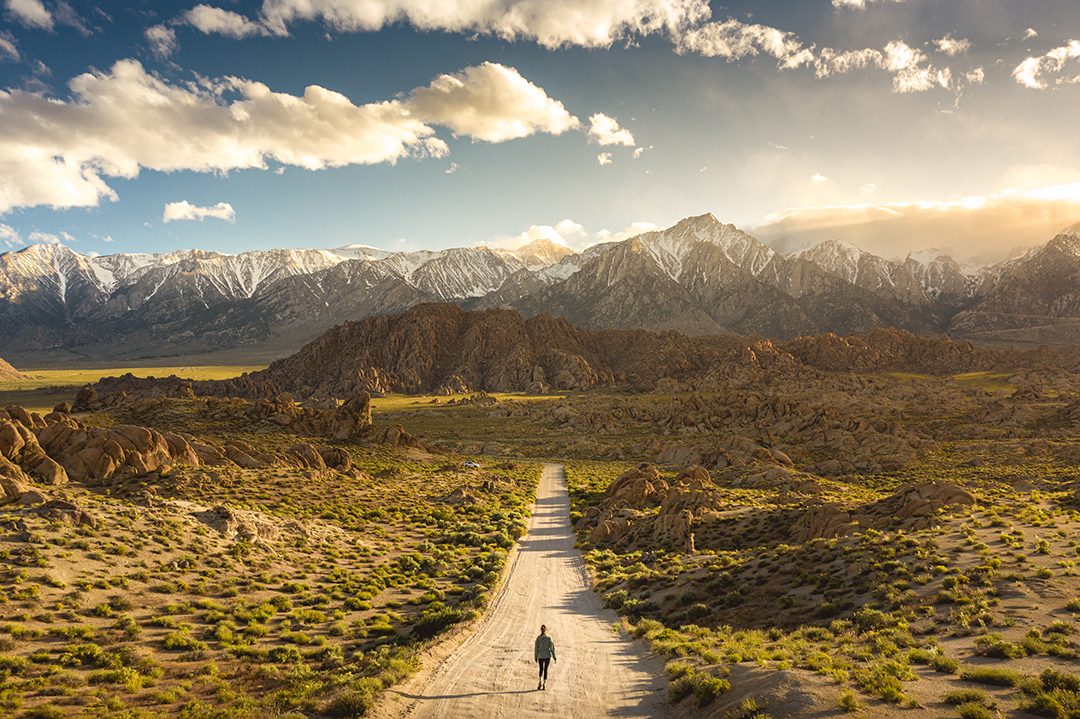 A lonely person walking on a pathway in Alabama hills in California with Mount Whitney in the background